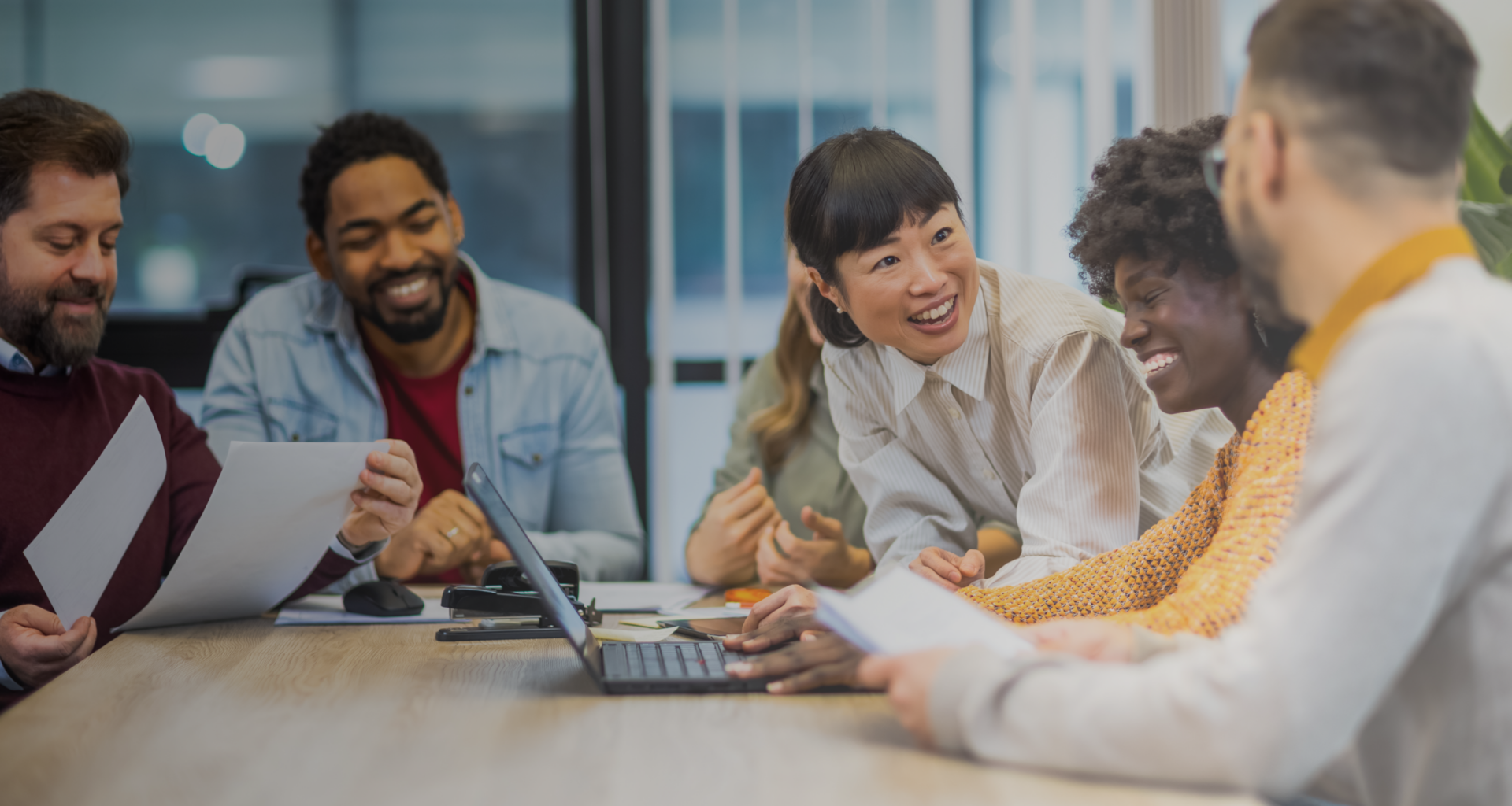 Multiethnic colleagues standing around the laptop. Finishing important job