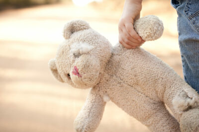 Runaway or Lost Girl Holding Old, Ragged Teddy Bear