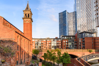 Modern blocks of flats alongside renovated brick buildings in Castlefield, Manchester, on a sunny summer day manchester building